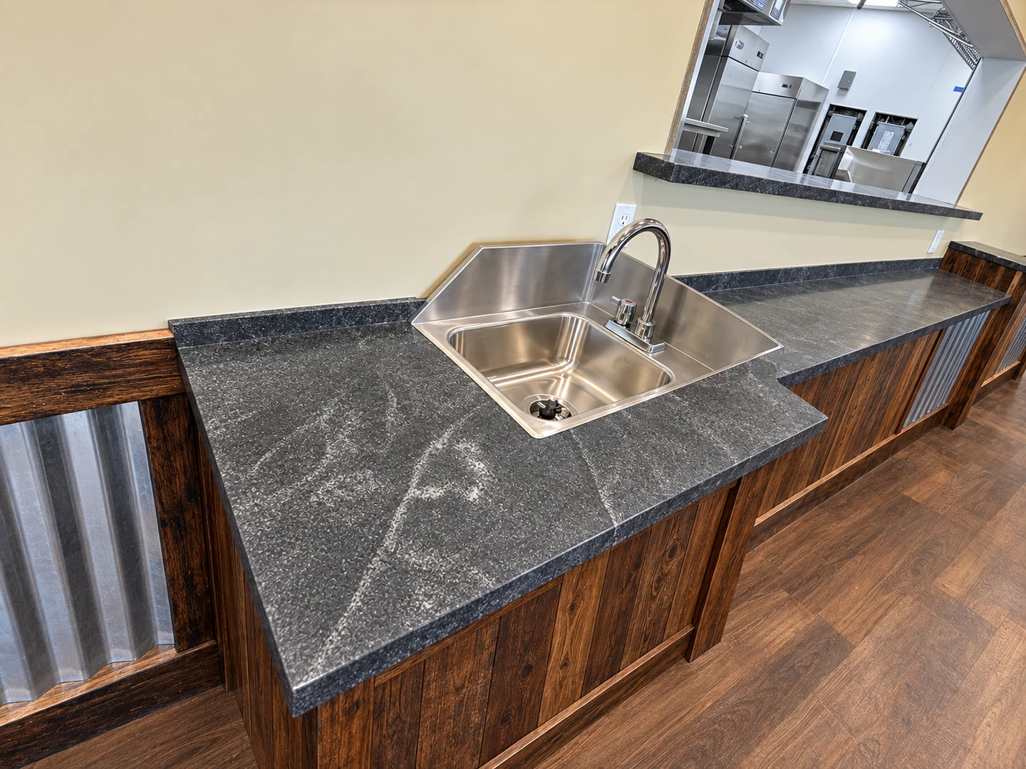 Dark patterned countertop around a stainless-steel sink; retouched setting, stone color and veining preserved