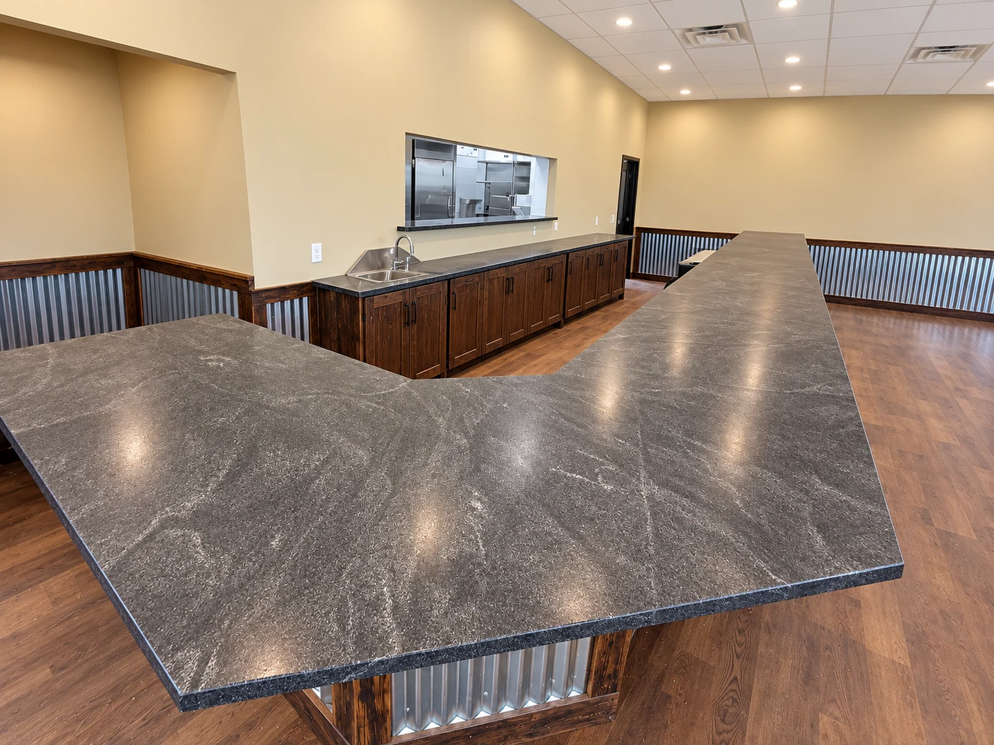 Wraparound dark stone bar with matching service counter; retouched setting, stone color and veining preserved