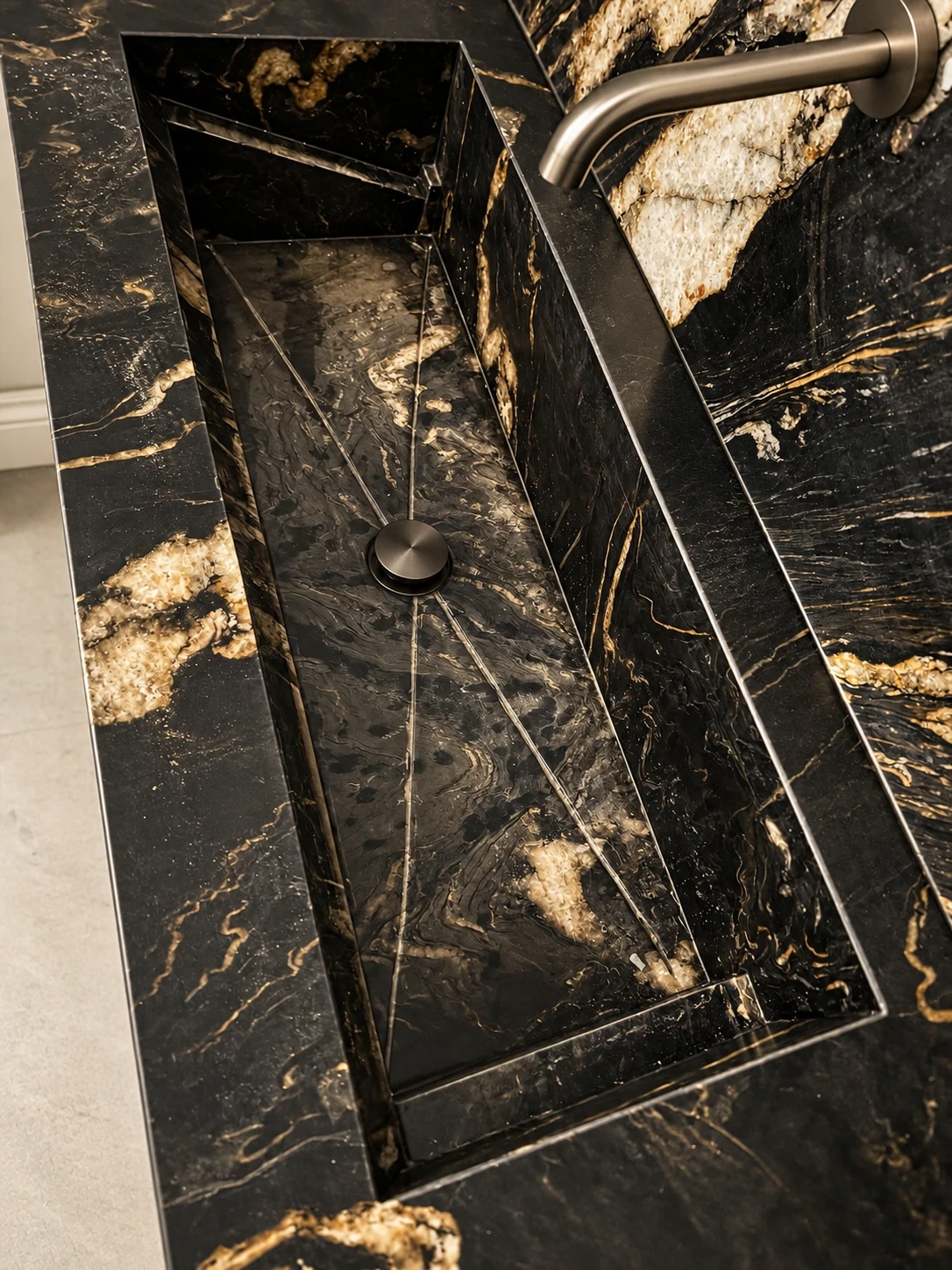 Close-up of a black and gold stone basin and matching wall; retouched setting, stone color and veining preserved