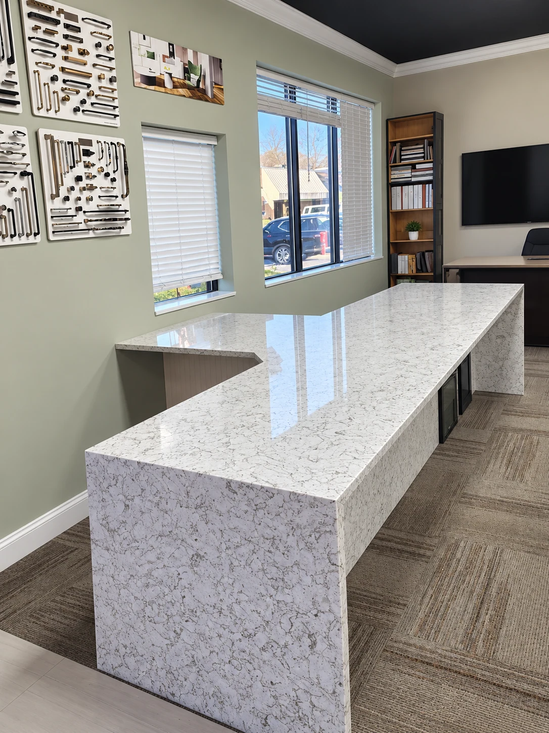 L-shaped stone desk with waterfall ends in a showroom setting; retouched setting, stone color and veining preserved