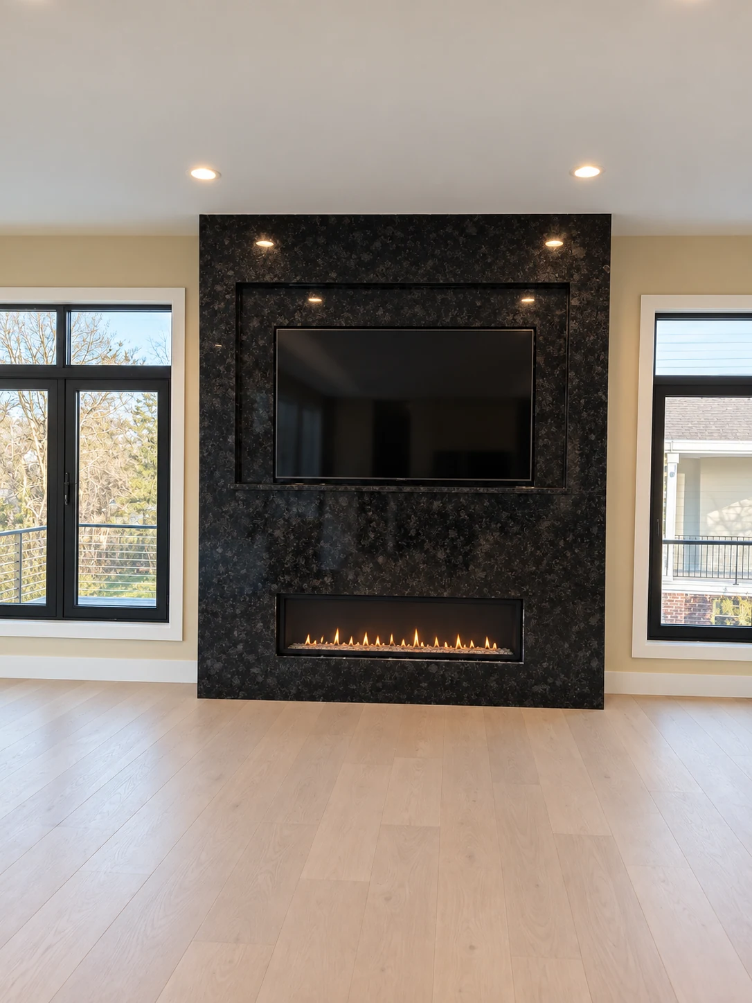 Dark stone fireplace and television surround between windows; retouched setting, stone color and veining preserved